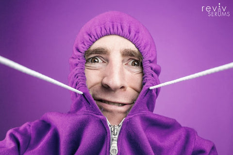 Guy covering up his scalp with hoodie